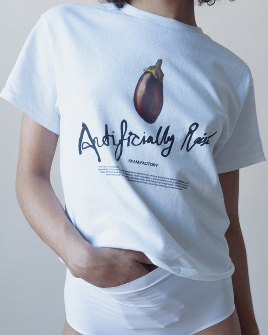 Unisex white 'Artificially Raised' t-shirt by 10:AM Factory, featuring a bold big eggplant graphic print and 10:AM logo, crafted from high-quality, soft cotton for a clean, modern look.