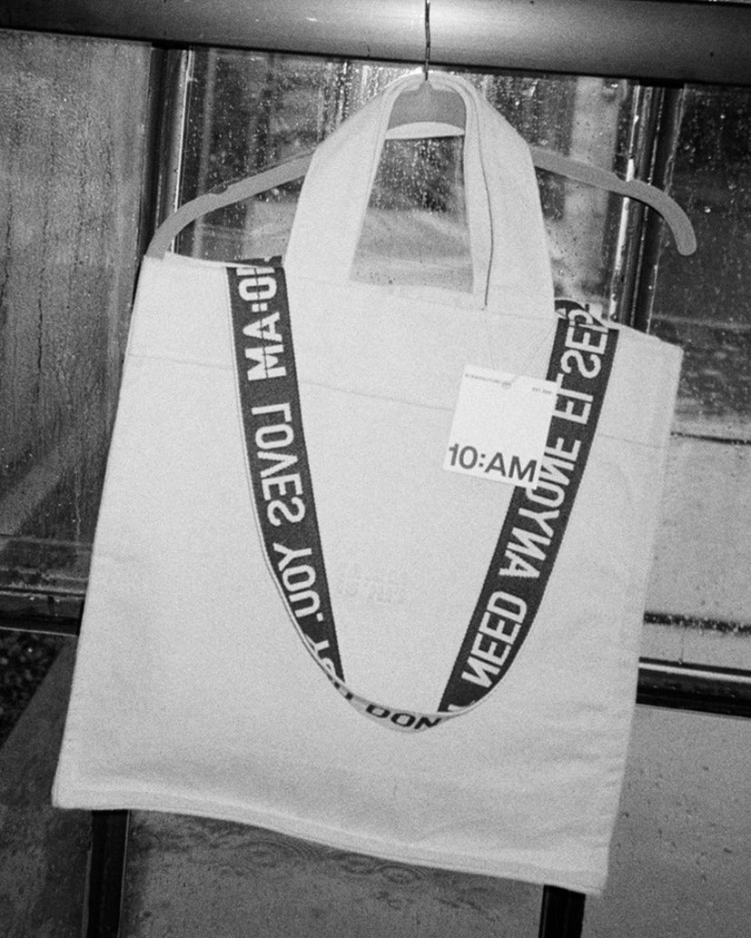 Unisex canvas tote bag by 10:AM Factory, featuring minimalist design and bold logo print, made from eco-friendly, sustainable materials.