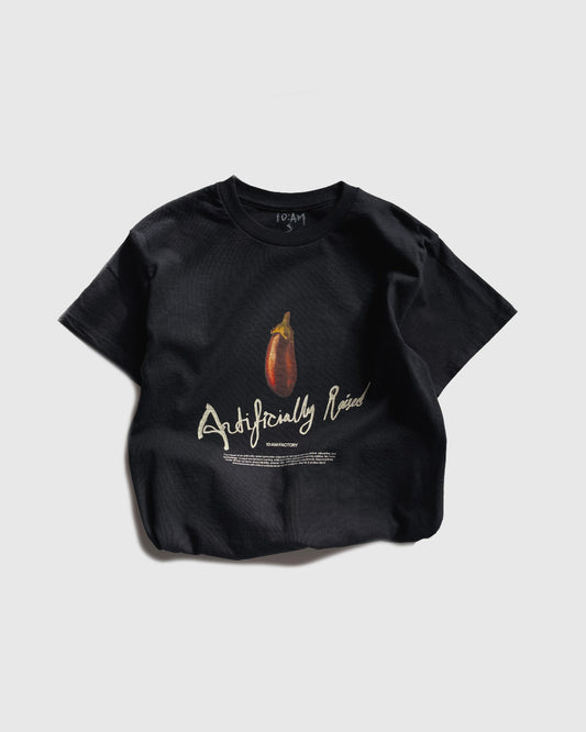 Unisex black 'Artificially Raised' t-shirt by 10:AM Factory, featuring a bold big eggplant graphic print and 10:AM logo, crafted from high-quality, soft cotton for a clean, modern look.