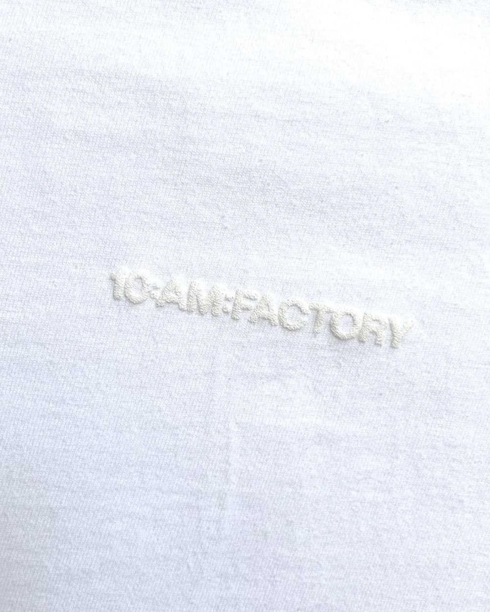 Unisex white 'Strange Mind' heavyweight t-shirt by 10:AM Factory, featuring a subtle white puff graphic print, crafted from high-quality, pigment-dyed cotton for a minimalist and timeless look.