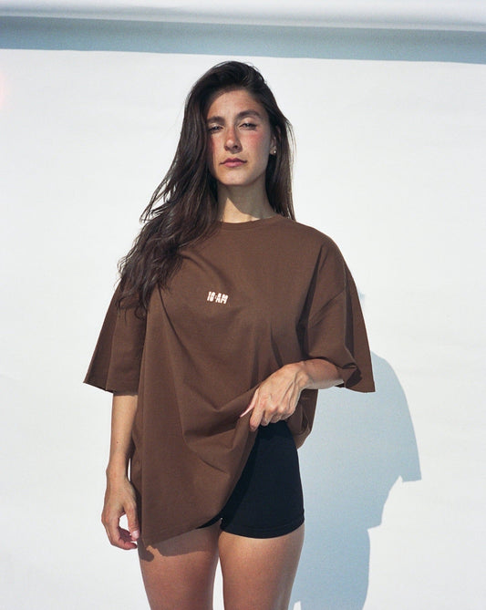 Unisex brown oversized t-shirt by 10:AM Factory, featuring the bold 'Sun Smells Different These Days' graphic print, crafted from high-quality, soft cotton for a relaxed, modern fit.